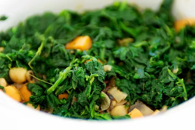 Stir the cooked spinach into crock pot.