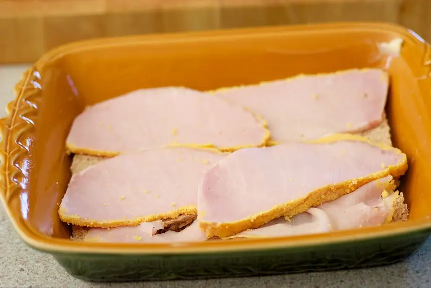Cover bread with cooked back bacon slices or ham slices. 