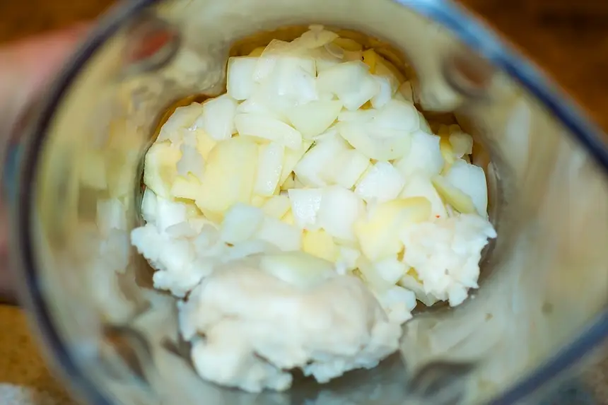 Add onion, garlic, ginger, apple, rice and water in a food processor or a blender.