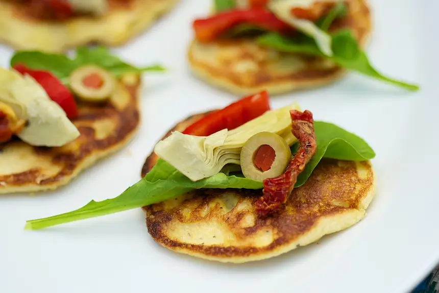Fresh Corn Blinis with Roasted Bell Pepper, Artichoke Hearts & Arugula