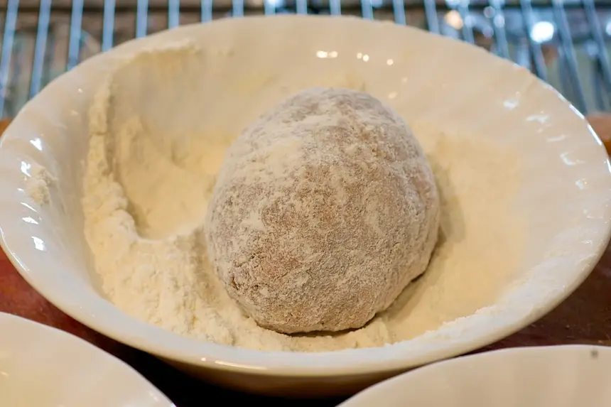 Place one prepared egg into <a href="/how-to/how-to-measure-flour" title="How to measure flour">flour</a> first.