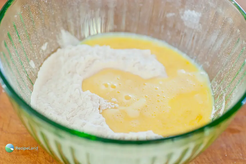 Add lightly beaten eggs and water to the sifted flour mixture