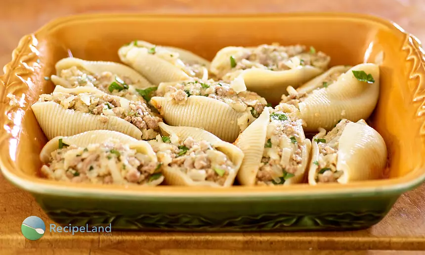 Pasta shells stuffed with beef in casserole dish, ready for the sauce