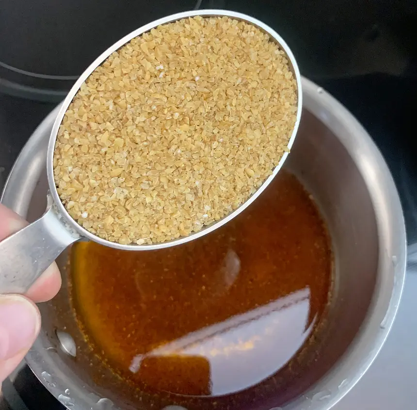 Bulgur in measuring cup ready for adding to pot