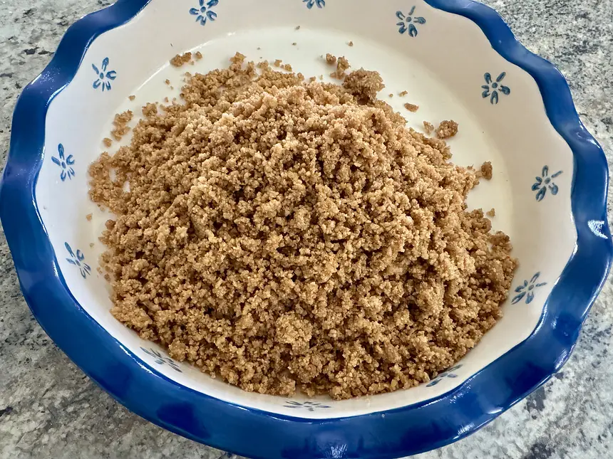 Graham wafer crumbs mixed with butter ready for forming into the pie plate