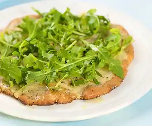 Cheesy & Garlicky White Pizza topped with Fresh Arugula