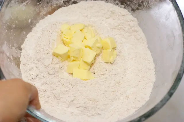 Add the butter into the <a href="/how-to/how-to-measure-flour" title="How to measure flour">flour</a> mixture.