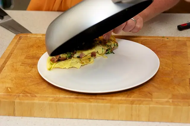 Invert and fold the omelette, rolling onto the plate
