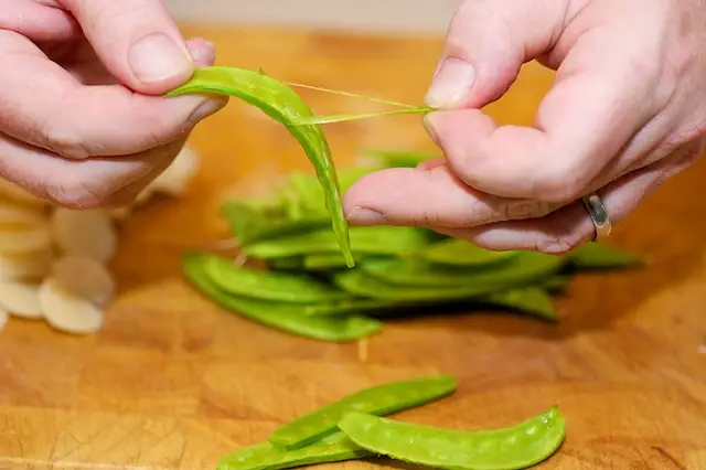 Remove the strings from the snow peas