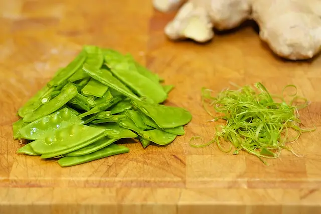 Strings are removed from the snow peas
