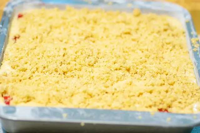 Sprinkle the prepared topping evenly over batter, and lay foil on lower rack to catch any juicy fruit spillovers.