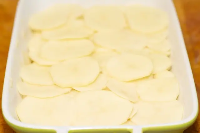 Repeat laying remaining potato slices over the sauce...