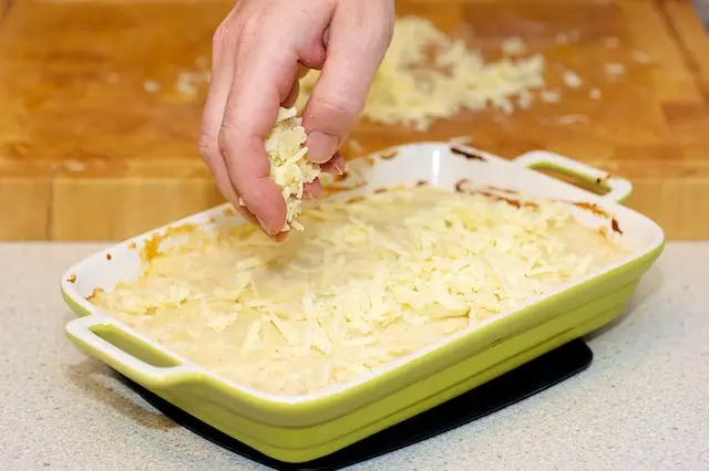 Sprinkle the cheese evenly over baked scalloped potatoes...