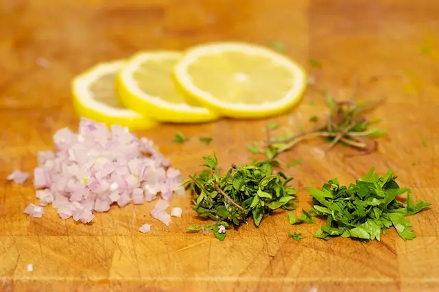 Slice the lemon and prep the herbs, don
