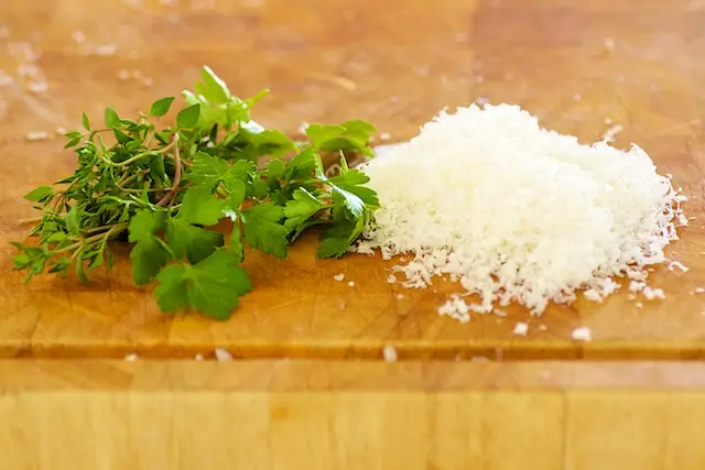 While the bread crumbs are baking, grate some parmesan and chop some fresh thyme leaves and parsley...