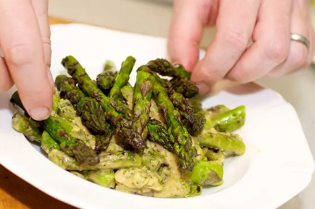 Arrange the tossed asparagus onto a serving platter,