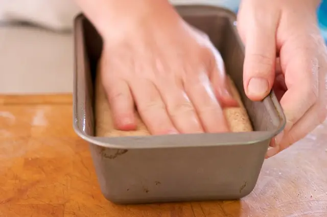Place each cylinder of dough into one of the prepared loaf pans and gently press it...