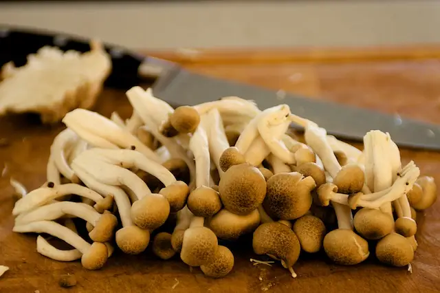 Trim off the ends of small brown mushrooms, then separate into pieces.