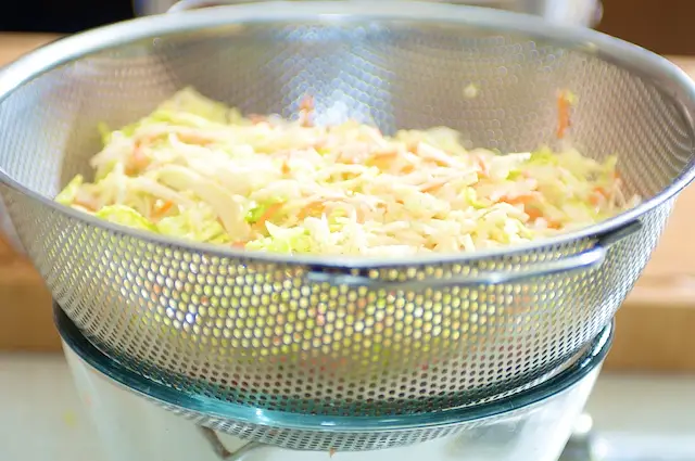 Transfer the slaw into a colander that sits over a large bowl or saucepan.
