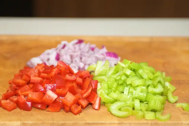 Thinly slice the celery, dice the pepper, and chop the onion.