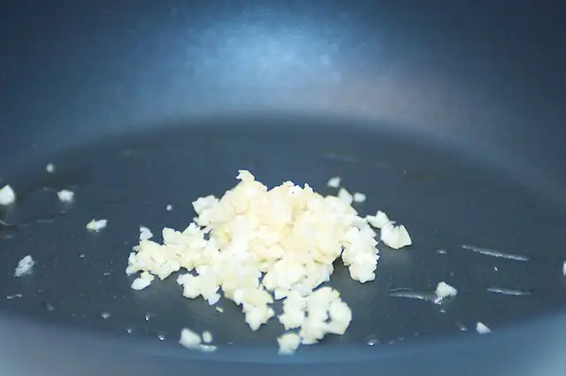 Add the garlic into a hot skillet with vegetable oil added.