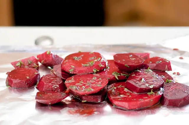 Toss beets in mixing bowl with garlic, thyme, balsamic vinegar, 2 tbsp olive oil and 1 tbsp lemon juice.