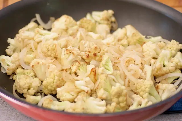 Keep cooking until the cauliflower florets starts to brown and onions are soft, 4 to 5 minutes.