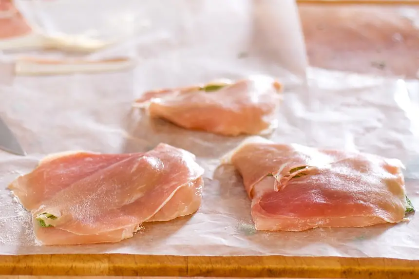 Add a layer of prosciutto onto each chicken cutlet, press to adhere