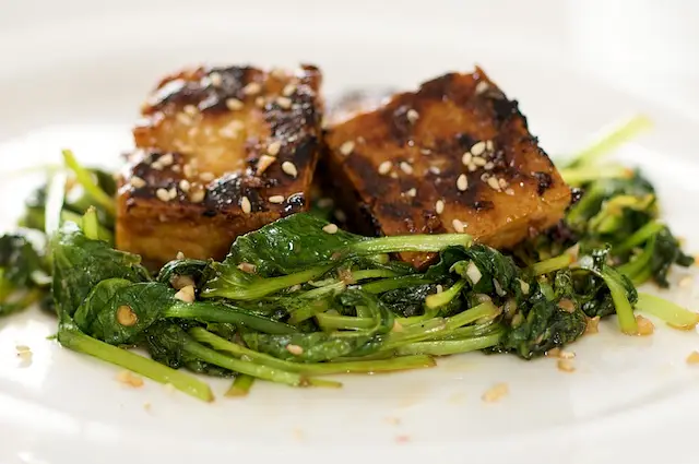 Divide the greens evenly among 4 serving plate. 