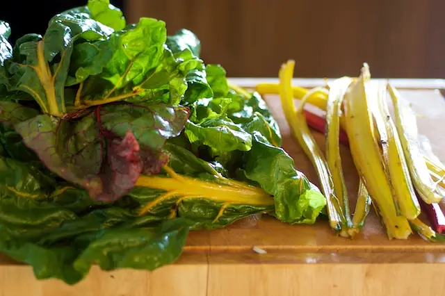 Meanwhile wash the chard very well, chop off the tough ends, and separate the stems and leaves.