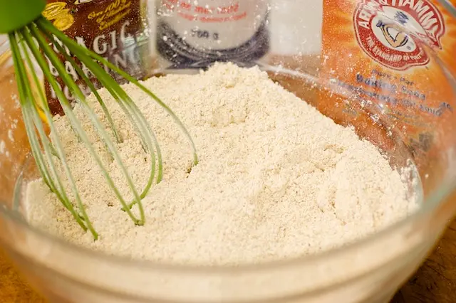 In a large bowl, whisk together the flours, corn meal, baking powder, baking soda and salt.