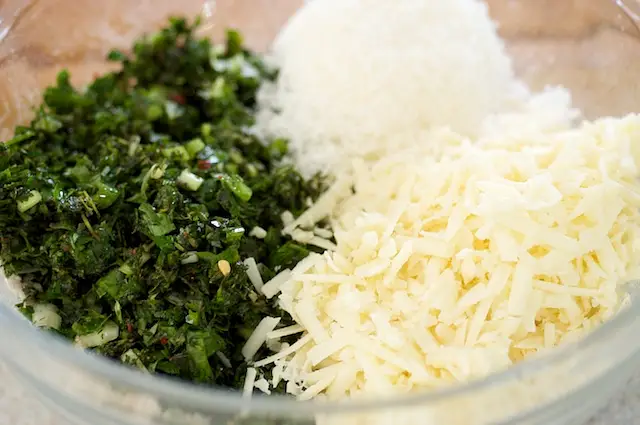 Add the shredded mozzarella cheese, grated parmesan, herb-olive mixture into the flour mixture.