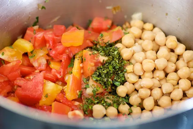 Add the chick peas, tomatoes, herbs,