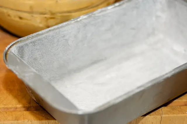 Grease and <a href="/how-to/how-to-measure-flour" title="How to measure flour">flour</a> the loaf pan.