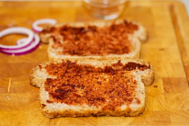 Spread each piece of bread with thin coating of pureed chiles,