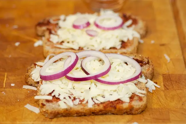 Cover bottom slice with layer of cheese, onion slices,