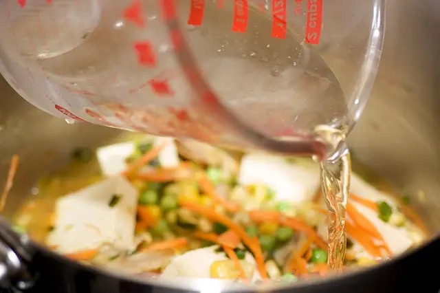Pour the water or stock into the pot.
