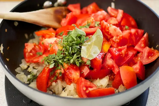 Add tomatoes, oregano and bay leaf. 