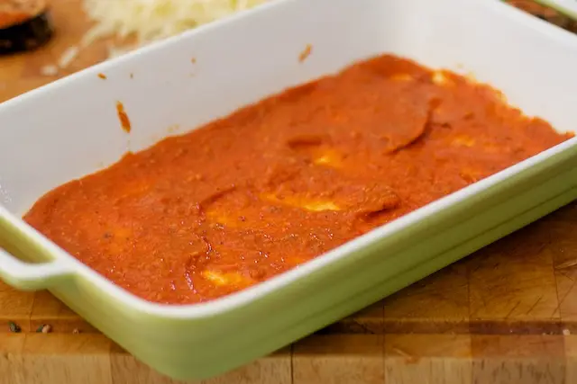 Time to assemble. Spread a thin layer of tomato sauce over the bottom of a 11 x 7 x 2 inch baking dish or a square dish. 