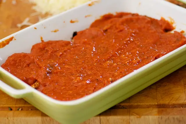 Spoon another layer of tomato sauce.