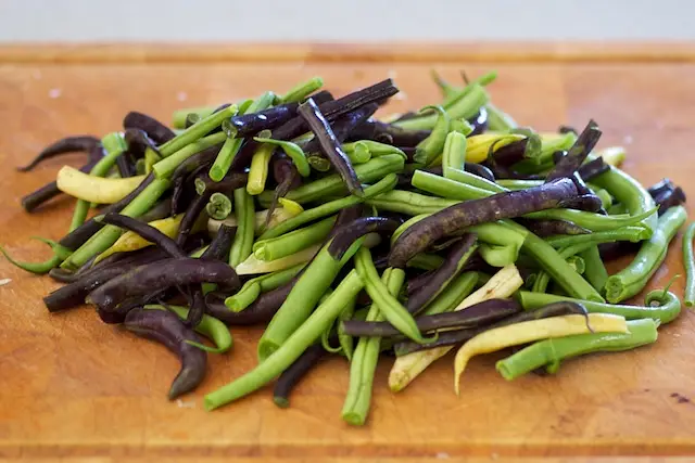 As the onions are cooking, rinse, trim and halve the green beans.