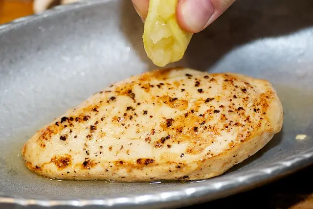 Place the chicken breasts onto a baking dish, squeeze lemon juice over.