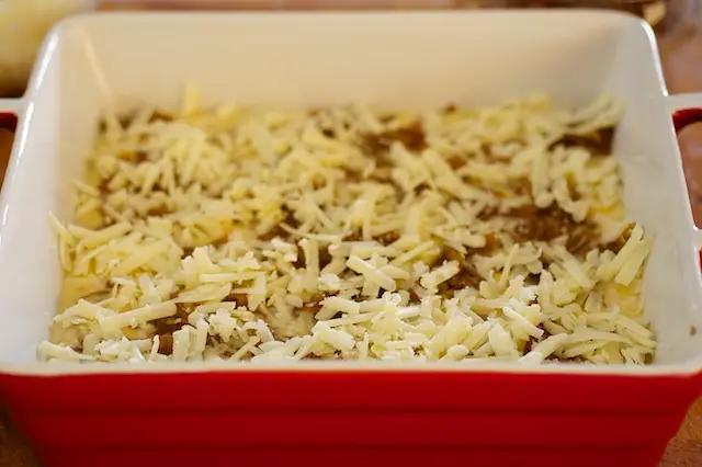 Spread half of the grated cheese over the onions.