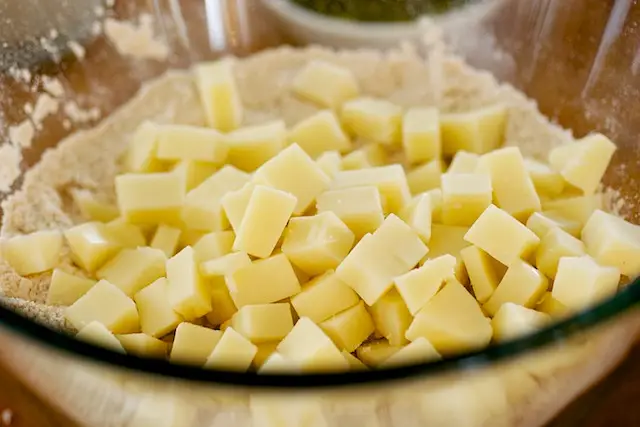 Add cheese into the <a href="/how-to/how-to-measure-flour" title="How to measure flour">flour</a> mixture, stir well. 