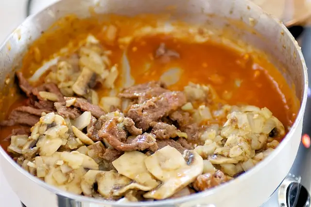 Return meat and mushrooms to skillet.