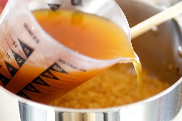 Pour in the broth and bring to a boil.  