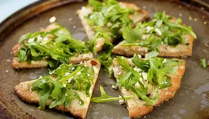 Cheesy and Garlicky White Pizza topped with Fresh Arugula 