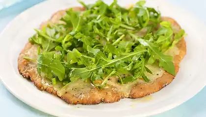 Cheesy and Garlicky White Pizza topped with Fresh Arugula 