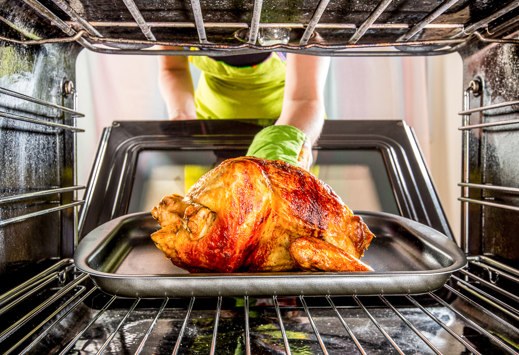 Removing roast chicken from an oven